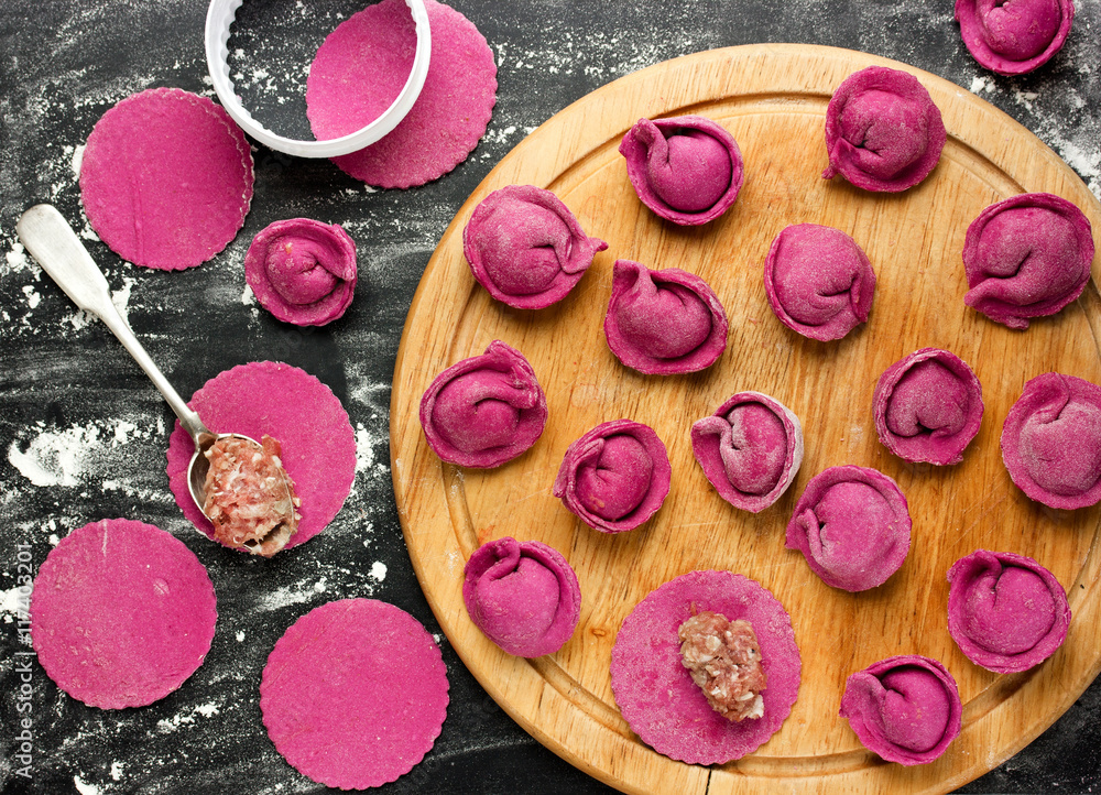 Cooking process concept - pink dumplings or ravioli