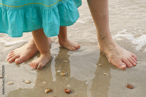 Mother and child walking on a sandy beach