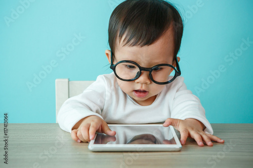 baby child using a pad./ Child playing with digital tablet on th