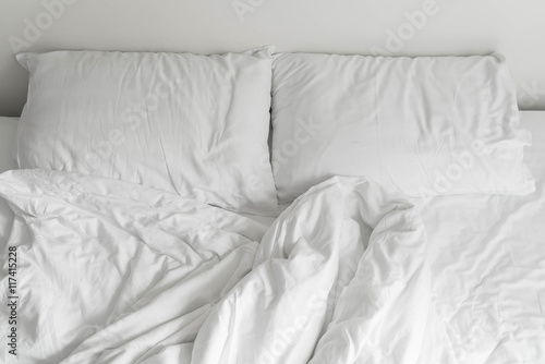 rumpled bed with white messy pillow decoration in bedroom