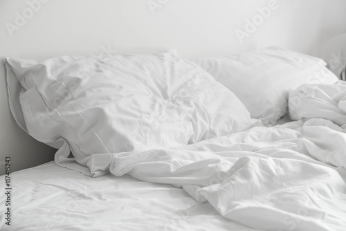 Fotografia rumpled bed with white messy pillow decoration in bedroom