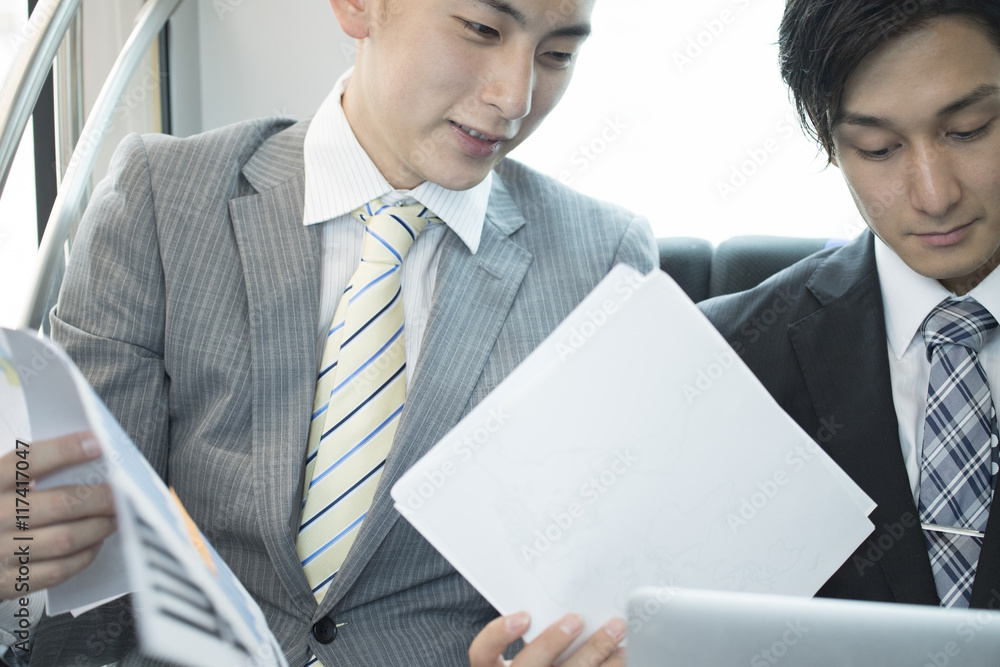 Two young businessmen have confirmed the documents on a train Two young businessmen have confirmed the documents on a train