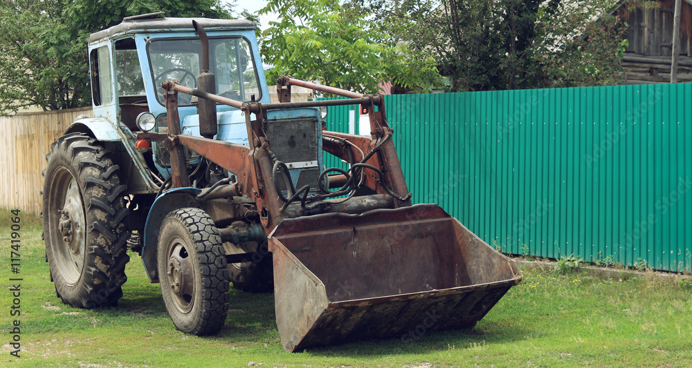 Fototapeta premium Old excavator near a house in the village