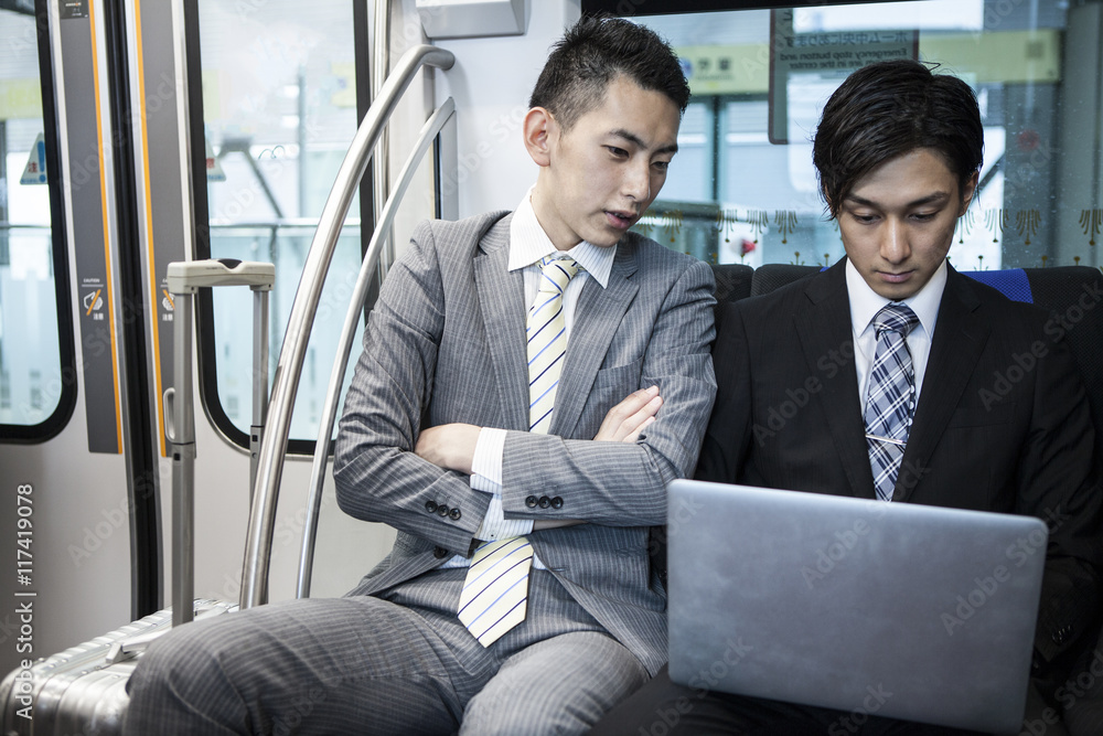 Businessman is using a laptop on a train Businessman is using a laptop on a train