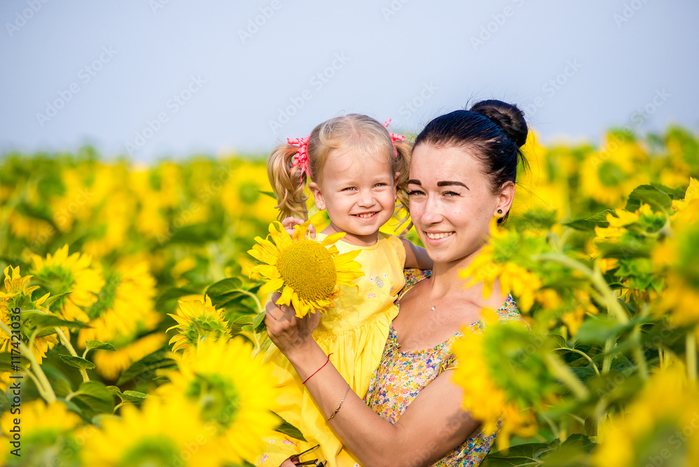 Mom and daughter in the field of sunflowers Mom and daughter in the field of sunflowers
