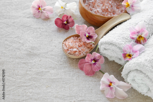 Pink sea salt and flowers  Spa setting  copy space background