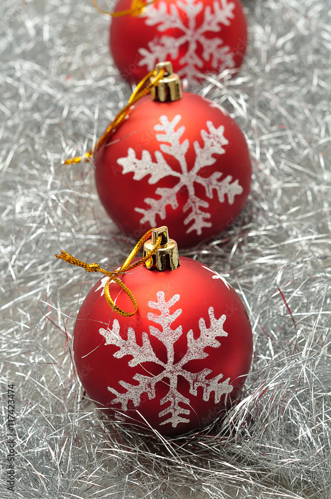 Red Christmas baubles with a silver star on a bed of silver tinsel Red Christmas baubles with a silver star on a bed of silver tinsel