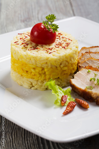Portion of risotto with roasted chicken.