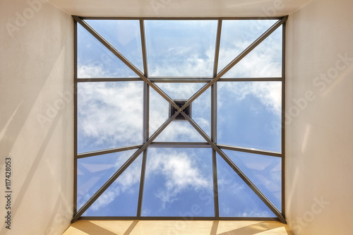 Window in a ceiling with blue sky and clouds  conceptual picture.