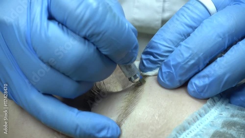 Microblading procedure. Master works with the eyebrows. Semi-permanent make-up.