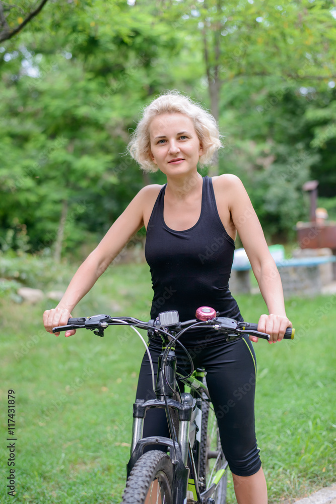 Naklejka premium Fit healthy middle aged woman riding a bike