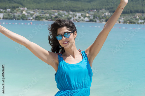 portrait of a beautiful young fashion  woman with blue dress on a sea background.Summer holiday