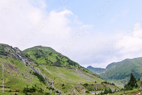 Photo of green capra peak  a small river and a road in fagaras mountains  Romania.