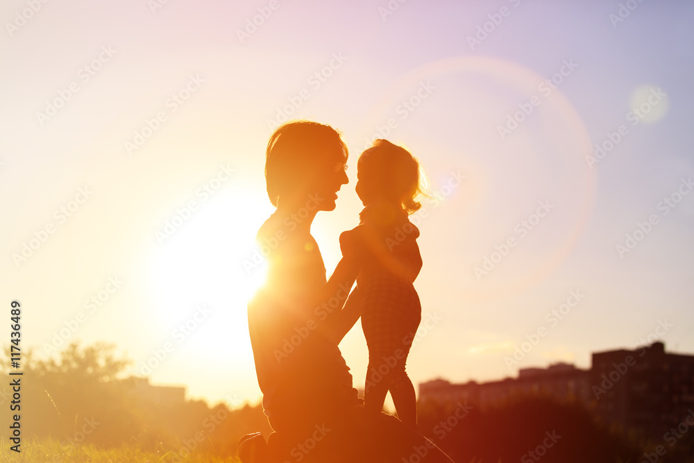 Father and little daughter silhouettes at sunset