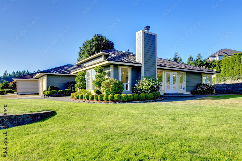 Nice curb appeal of modern blue house with well kept lawn