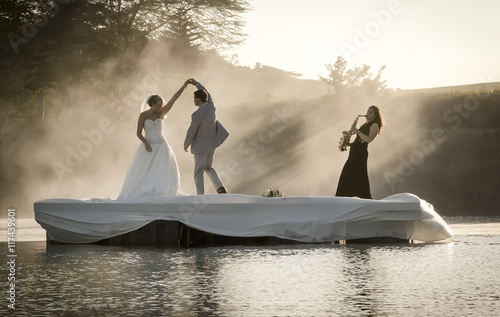 Bride and Groom dancing on a lake to music.