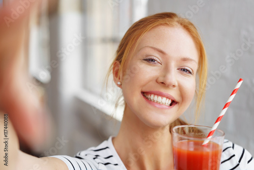 lachende frau trinkt tomatensaft photo