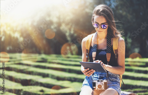 Photography Hipster young girl with backpack and vintage camera using tablet or gadget