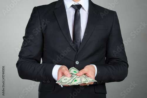 Unrecognizable businessman shows dollar banknote