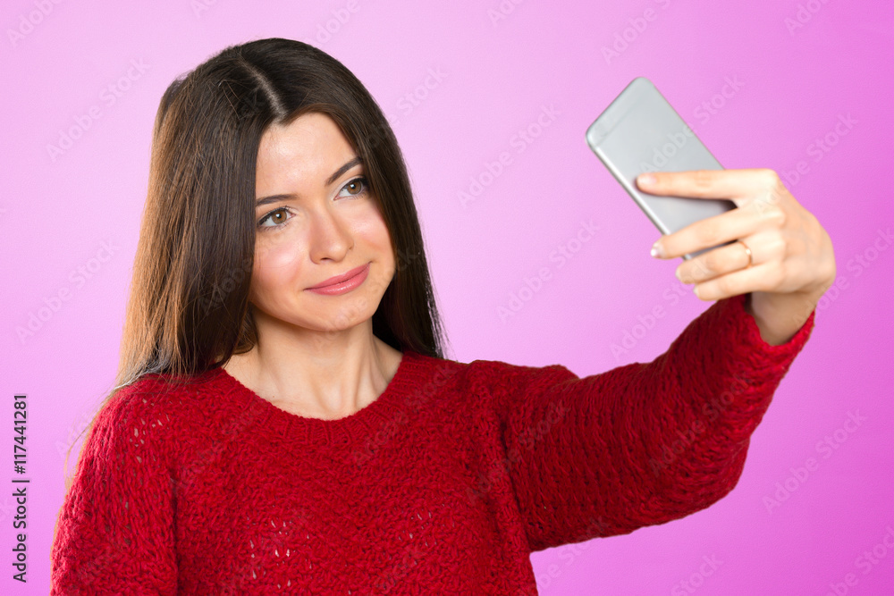 Beautiful young woman is making selfie photo with smartphone Beautiful young woman is making selfie photo with smartphone