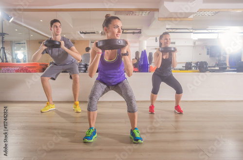 Three people fitness gym squat weights hand