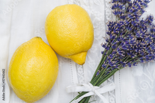 Fototapeta Naklejka Na Ścianę i Meble -  Bouquet of purple lavender with yellow lemons on lace cloth