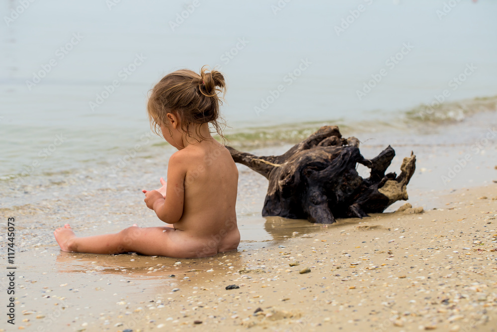 little nakend naked little girl plays in the sea, beautiful beach Stock ...