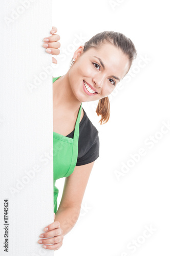 Attractive female employee standing behind blank banner