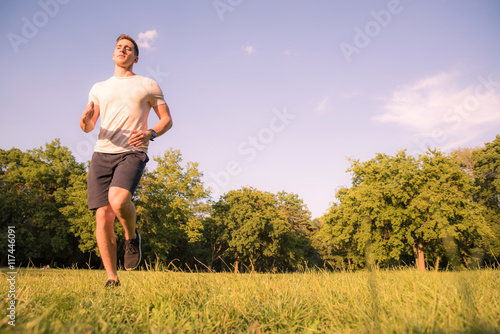 A handsome young man running in a park 