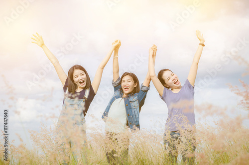 Three happy asian girls in grass field with vintage filter