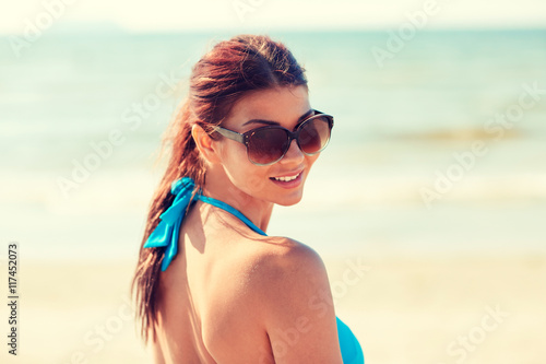 smiling young woman with sunglasses on beach © Syda Productions
