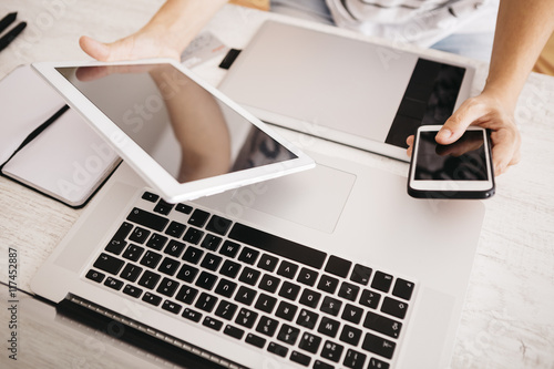 Young woman using different devices to work on the network photo