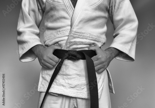 Martial arts Master tightening black belt. Black and white toning