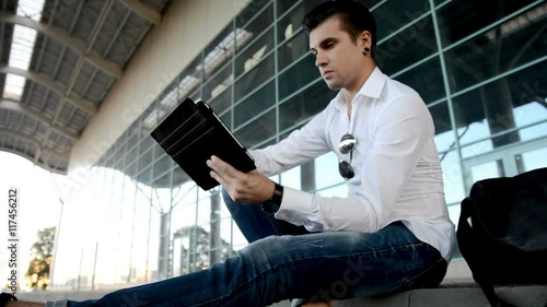 Wallpaper Mural Man with tablet computer sitting by the city street Torontodigital.ca