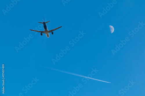 Fototapeta Naklejka Na Ścianę i Meble -  Plane taking off, plane high in the sky and moon.