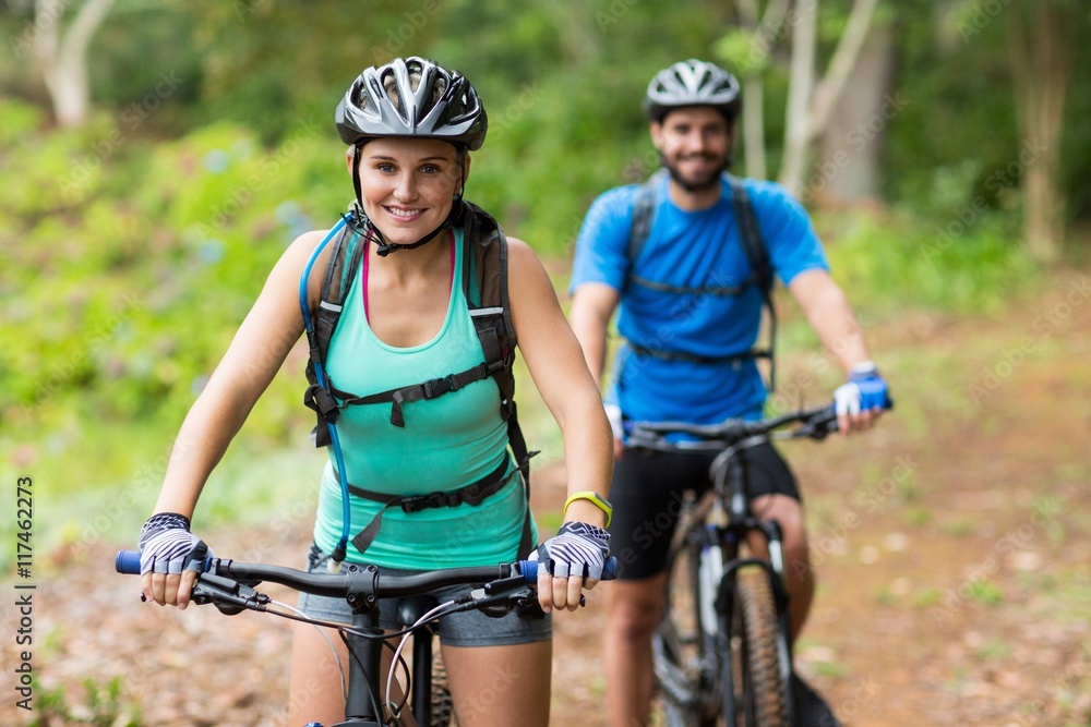 Naklejka premium Athletic couple cycling in forest