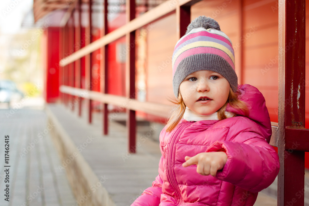 little fashionista, stylish girl on the streets. the child eats little fashionista, stylish girl on the streets. the child eats