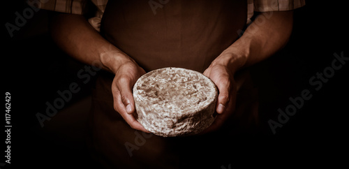 Принти на полотні French tomme cheese in the hands of a cheesemaker