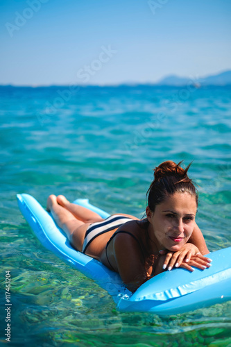 Girl looking at the camera while floating on the water
