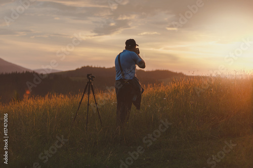 Photographer shoots landscape at sunset