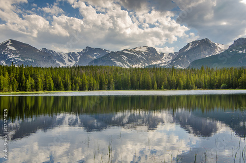 Landscape of mountains and forest reflected in a lake.