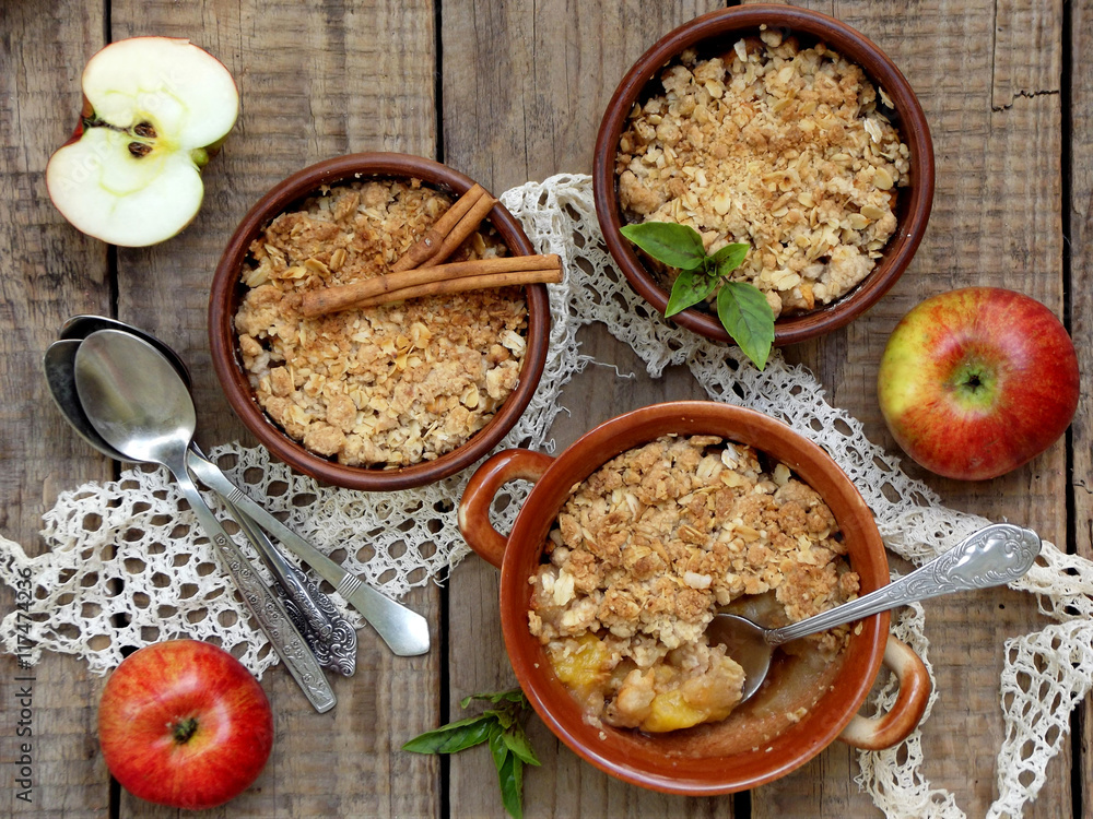 Cheese casserole or crumble with apples and cinnamon in brown cup ramekin on wooden background Cheese casserole or crumble with apples and cinnamon in brown cup ramekin on wooden background