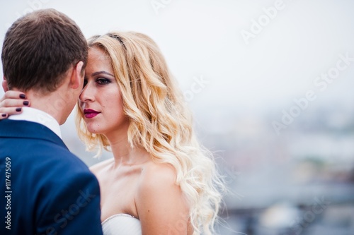 Close up portrait of charming blonde bride with groom