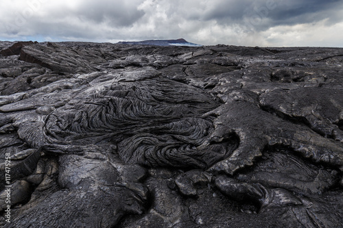 Bizarre formations on the lava fields of Puu Oo, Big Island Hawaii. The shiny rock consists of very fresh lava. The cone of Puu Oo is visible in the background.