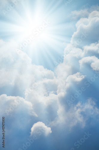 Bright sun shines among the white clouds