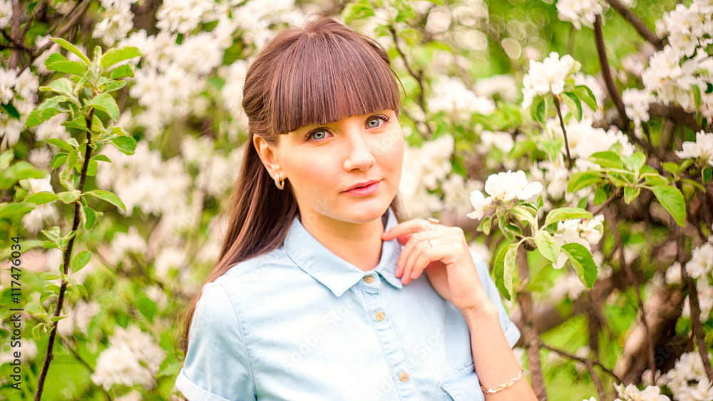 Portrait of pretty young brunette posing in flowering trees Portrait of pretty young brunette posing in flowering trees
