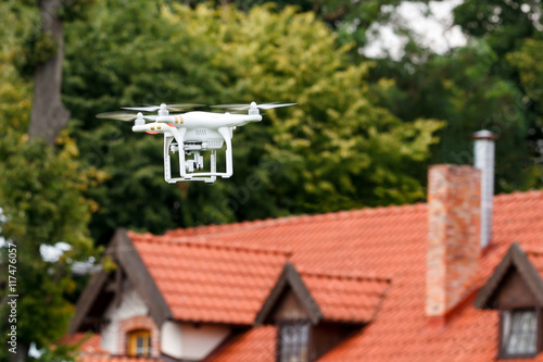 Modern RC Quadcopter. RC Drone with camera flying over the roof of the house. selective focus