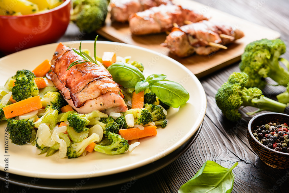 Baked chicken breast wrapped in bacon slices with boiled potatoes and steamed broccoli, carrot, garlic, onion Baked chicken breast wrapped in bacon slices with boiled potatoes and steamed broccoli, carrot, garlic, onion