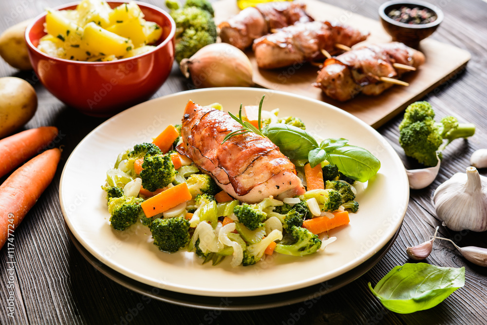 Baked chicken breast wrapped in bacon slices with boiled potatoes and steamed broccoli, carrot, garlic, onion Baked chicken breast wrapped in bacon slices with boiled potatoes and steamed broccoli, carrot, garlic, onion