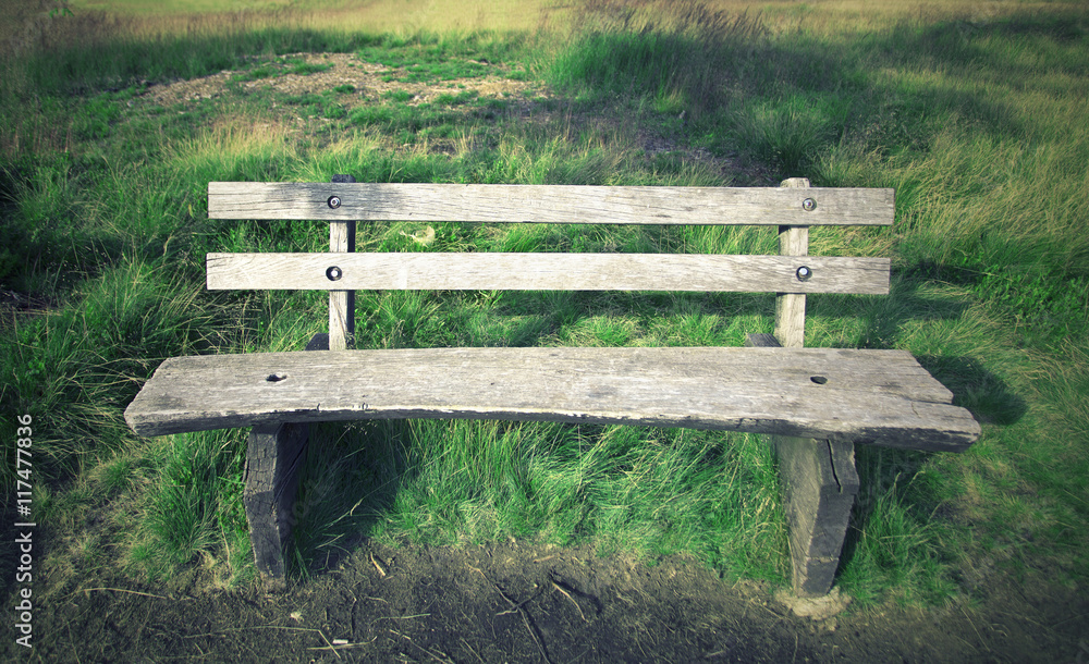 Closeup of old wooden bench on sunny park meadow. Closeup of old wooden bench on sunny park meadow.